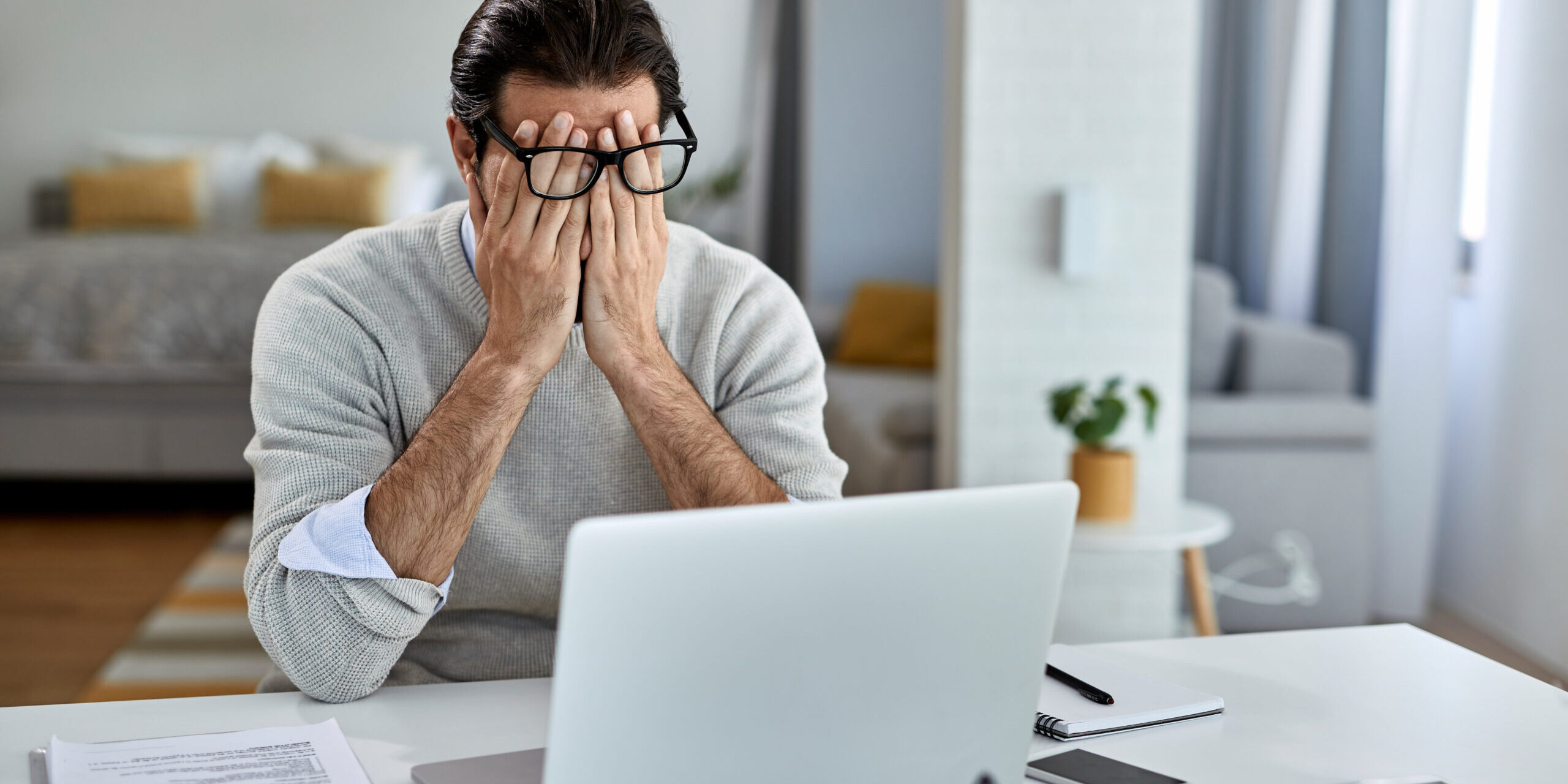 Tired male entrepreneur working on a computer at home.